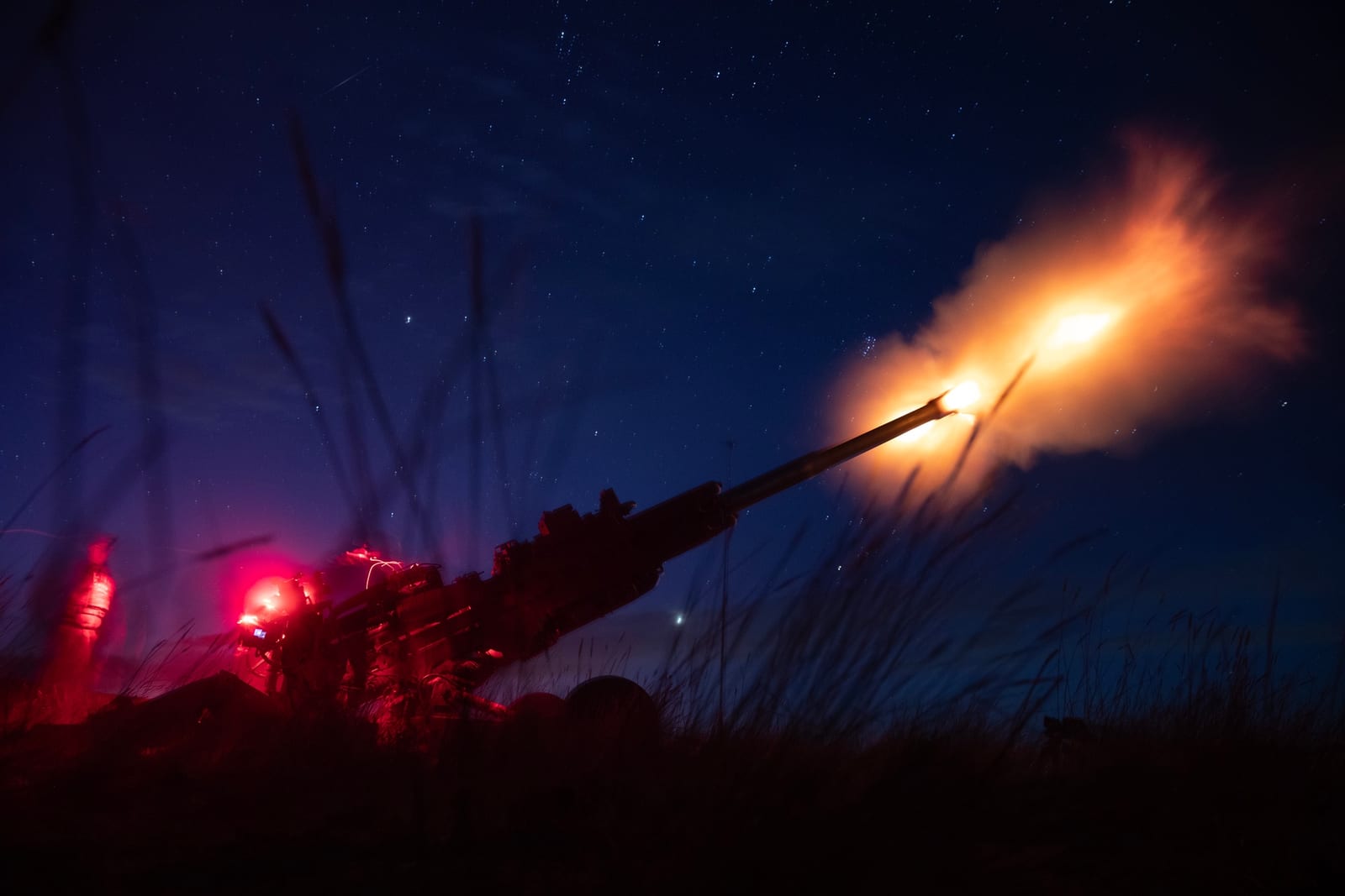 U.S. Army National Guard soldiers fire an M777 towed howitzer during nighttime live-fire training