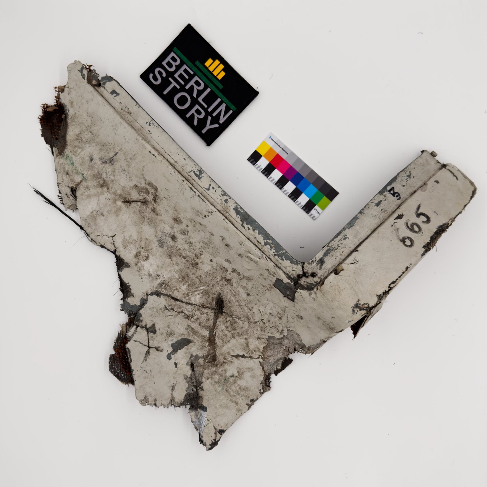 Recovered fragment of a downed Shahed-136 attack drone airframe with a 10-centimeter scale reference