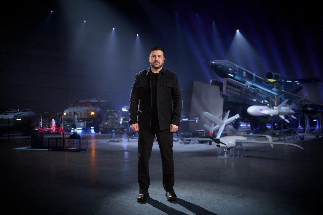Ukrainian President Volodymyr Zelenskyy standing before a display of Ukrainian-made military equipment including the Flamingo cruise missile