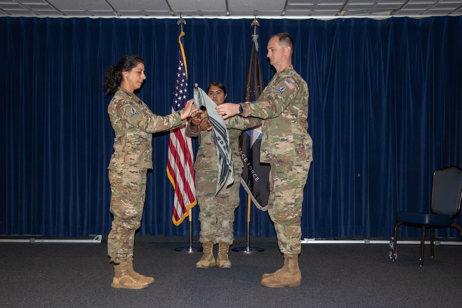 Col. Nicole Petrucci, commander of Space Delta 3, and Maj. Zachary Scoggins, commander of the 23rd Electromagnetic Warfare Squadron, unfurl the squadron's guidon at its activation ceremony