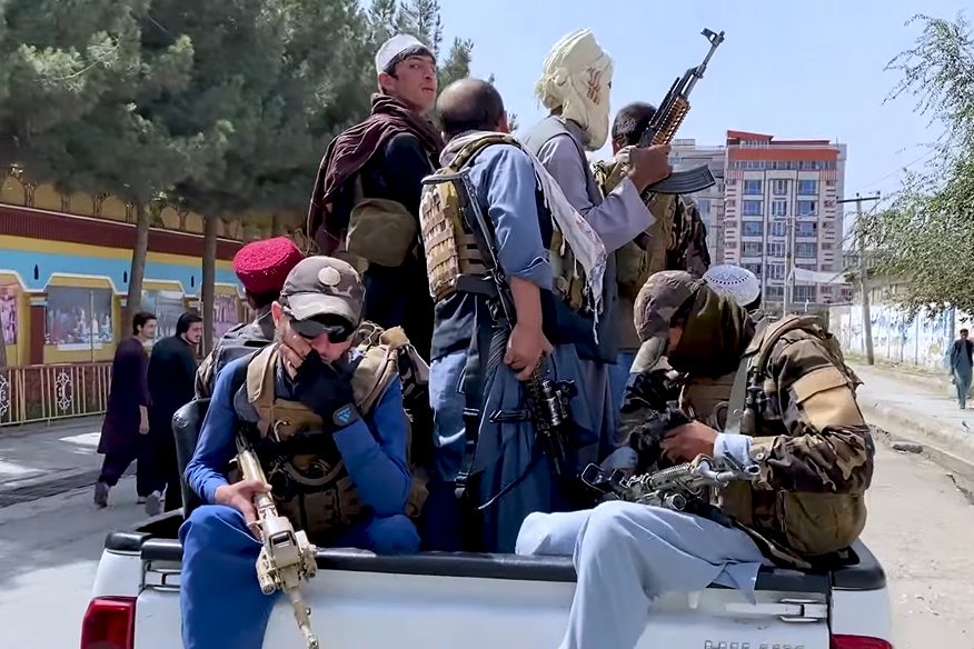 Armed Taliban fighters with a pickup-mounted weapon on a street in Taliban-controlled Kabul, days after the city's fall