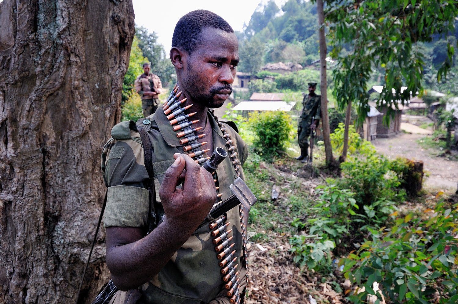 M23 fighters in fatigues standing with weapons at Bunagana, a border town between DRC and Uganda