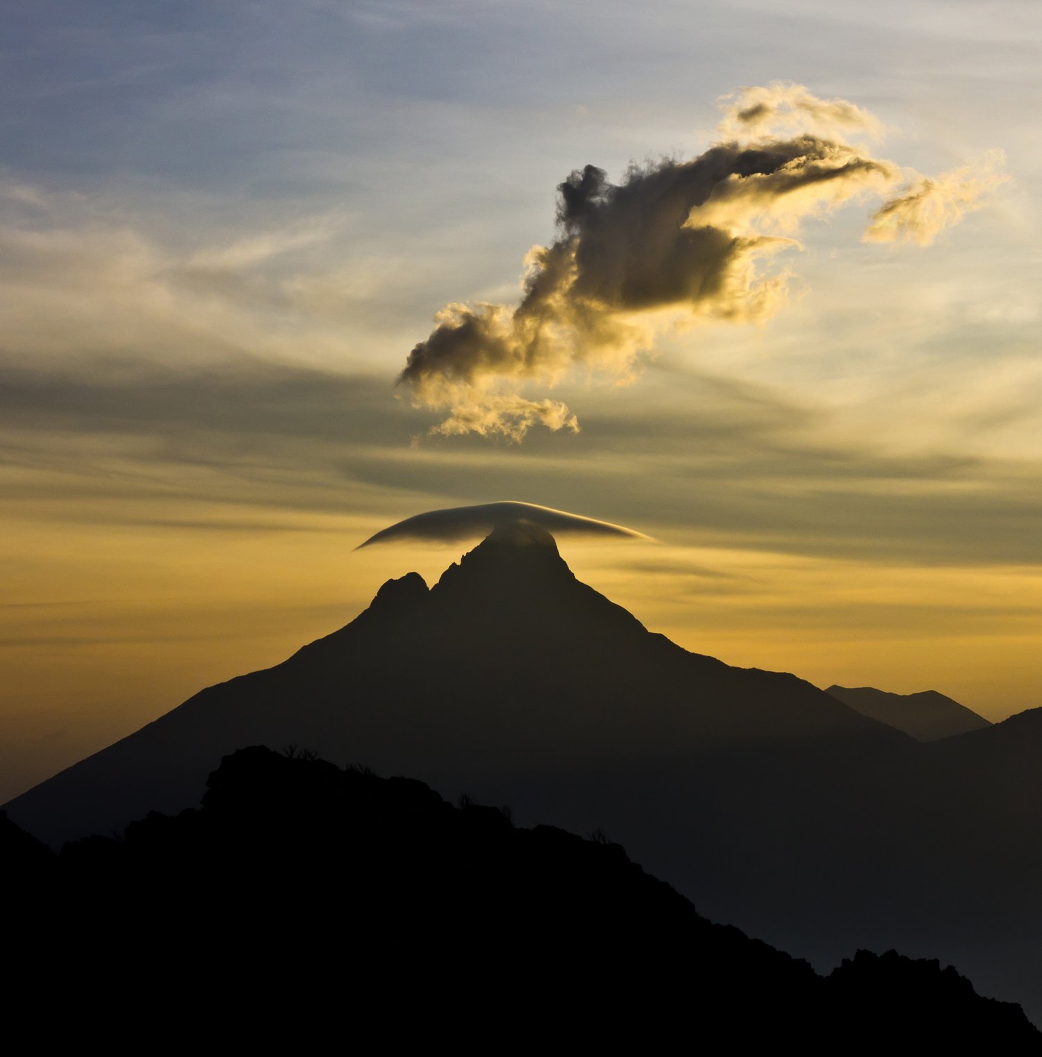 The volcanic peak of Mont Mikeno in Virunga National Park, North Kivu, with clouds forming around its summit