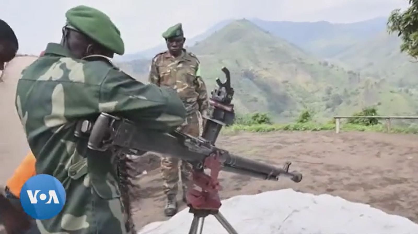 A group of armed Wazalendo militia fighters in mismatched fatigues walking down a dirt road
