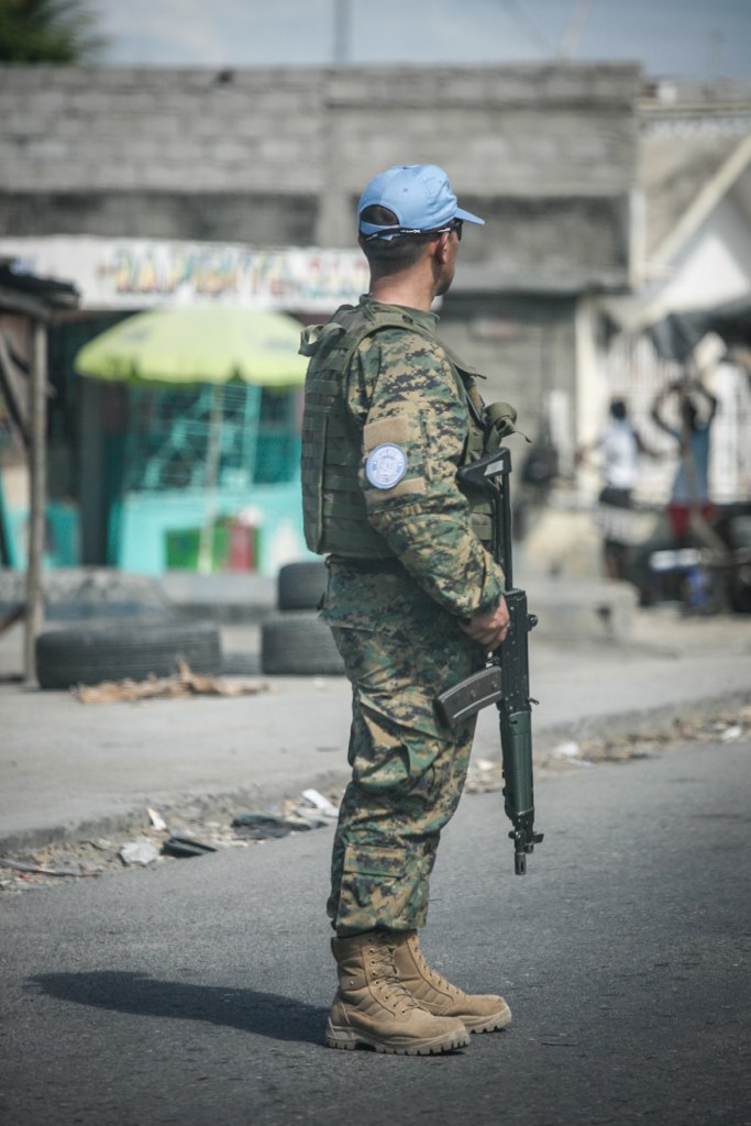 Armed United Nations peacekeeping personnel conducting a street patrol on a road in Haiti