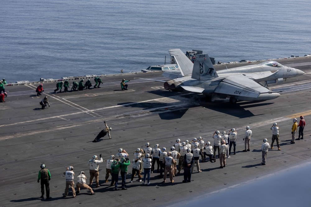 Distinguished visitors observe flight operations on the flight deck of the Nimitz-class aircraft carrier USS Abraham Lincoln in the Arabian Sea, three weeks before the carrier supported the war's opening strikes