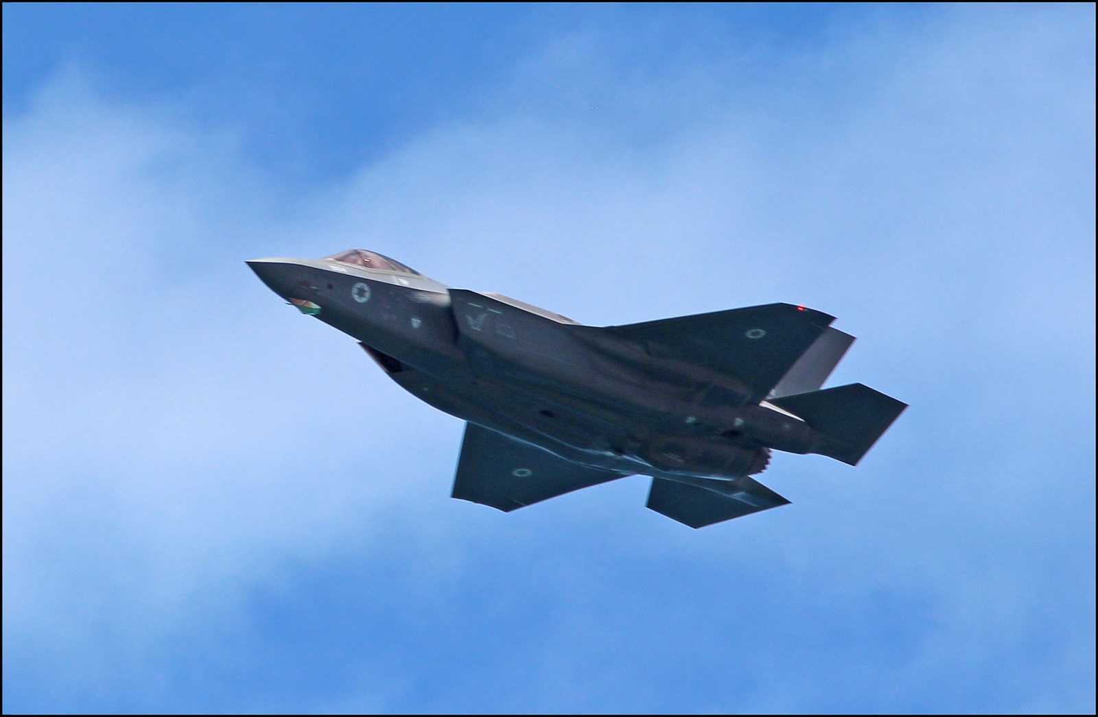 An Israeli Air Force F-35I Adir stealth fighter jet in low-altitude flight over a coastline