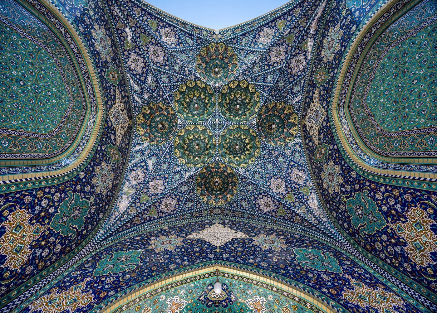 An ornate mirrored iwan entrance of the Fatima Masumeh Shrine in Qom, Iran