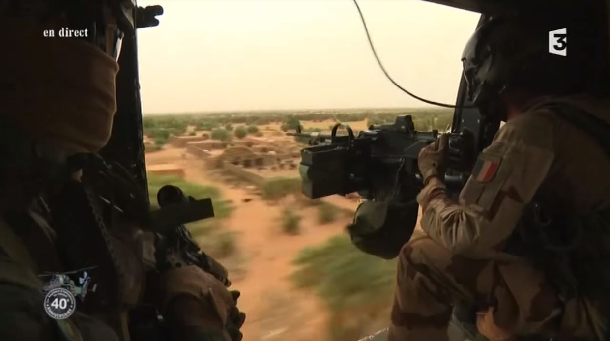 French and Malian soldiers standing together near military vehicles northeast of Gao, Mali