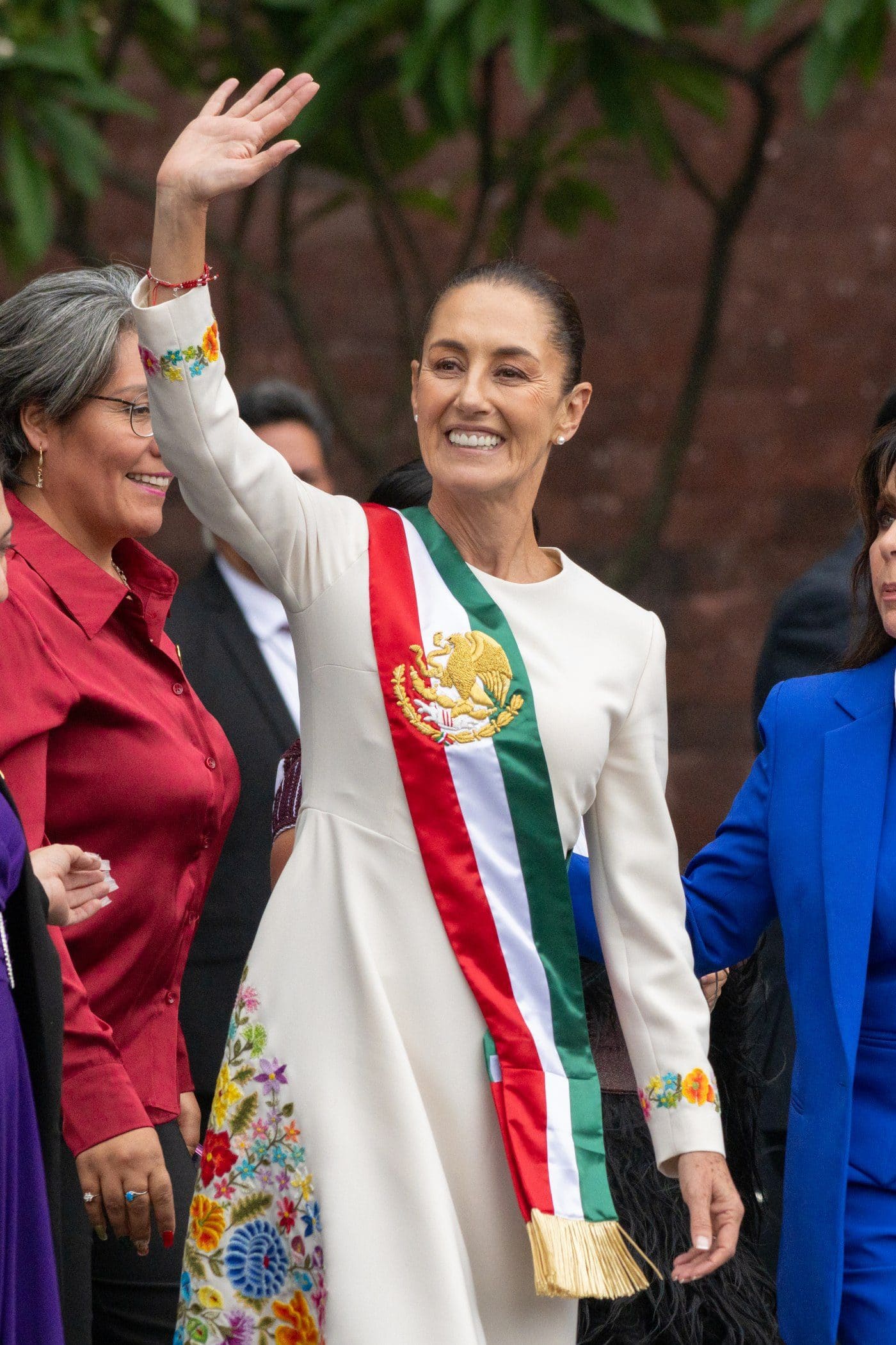 Claudia Sheinbaum waving and wearing the Mexican presidential sash after being sworn in