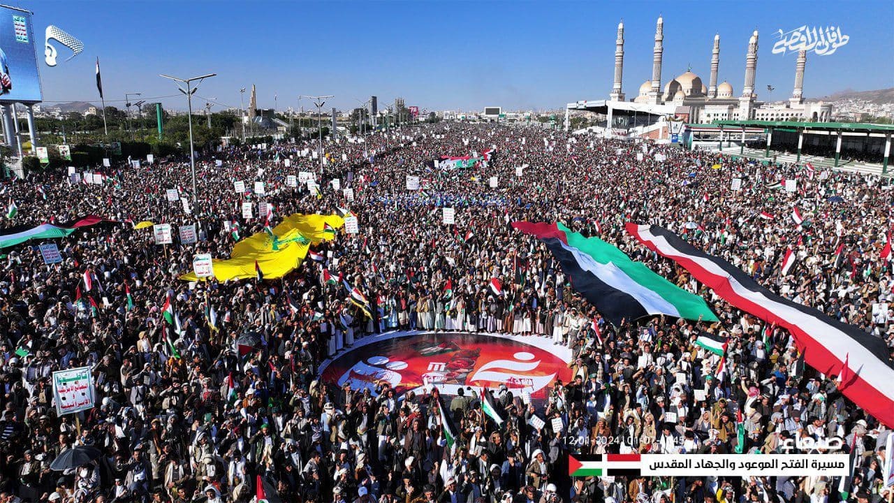 A large crowd of demonstrators holding signs and flags at a rally in Sanaa, Yemen, in January 2024