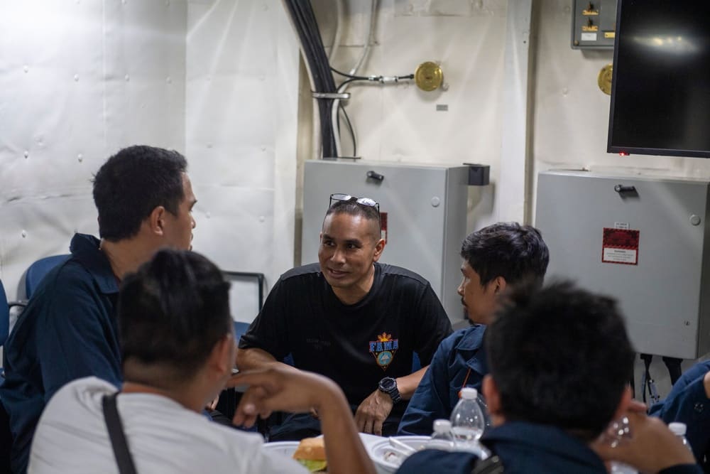 A sailor aboard the carrier USS Dwight D. Eisenhower speaks with rescued mariners from the coal carrier Tutor in the Red Sea, June 15, 2024
