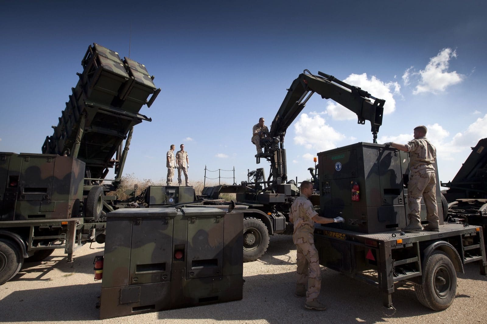 A Dutch Patriot surface-to-air missile launcher and support vehicles deployed in an open field