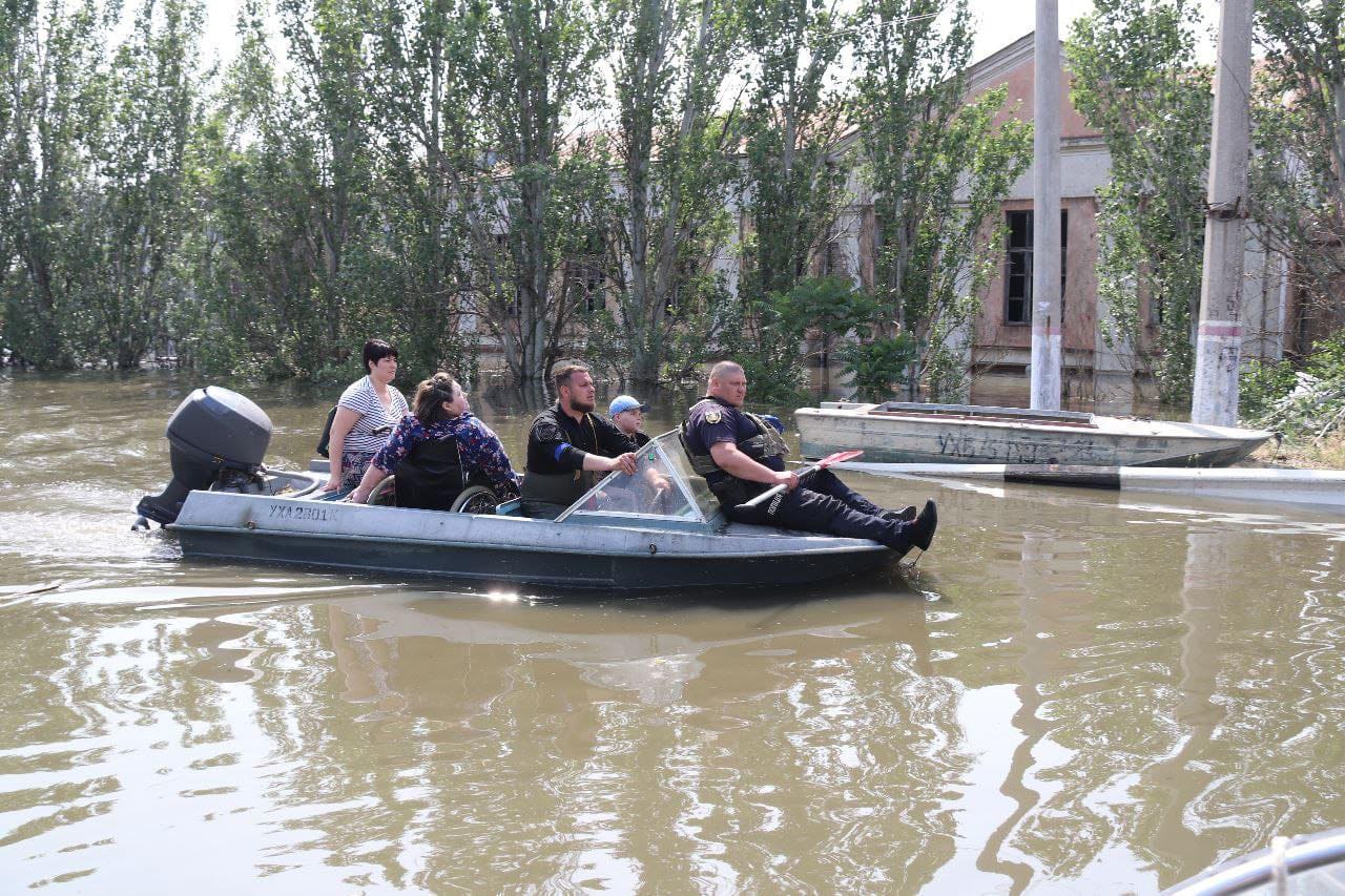 Ukrainian police conducting evacuations by boat through a flooded street in Kherson Oblast after the Kakhovka Dam breach