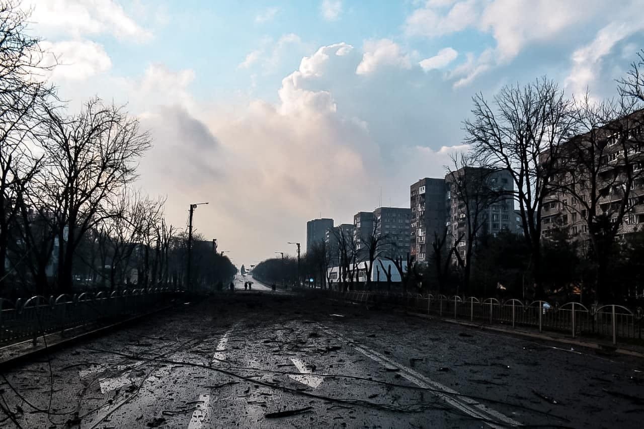 A debris-strewn downtown street in Mariupol lined with damaged high-rise apartment buildings during the Russian siege of the city