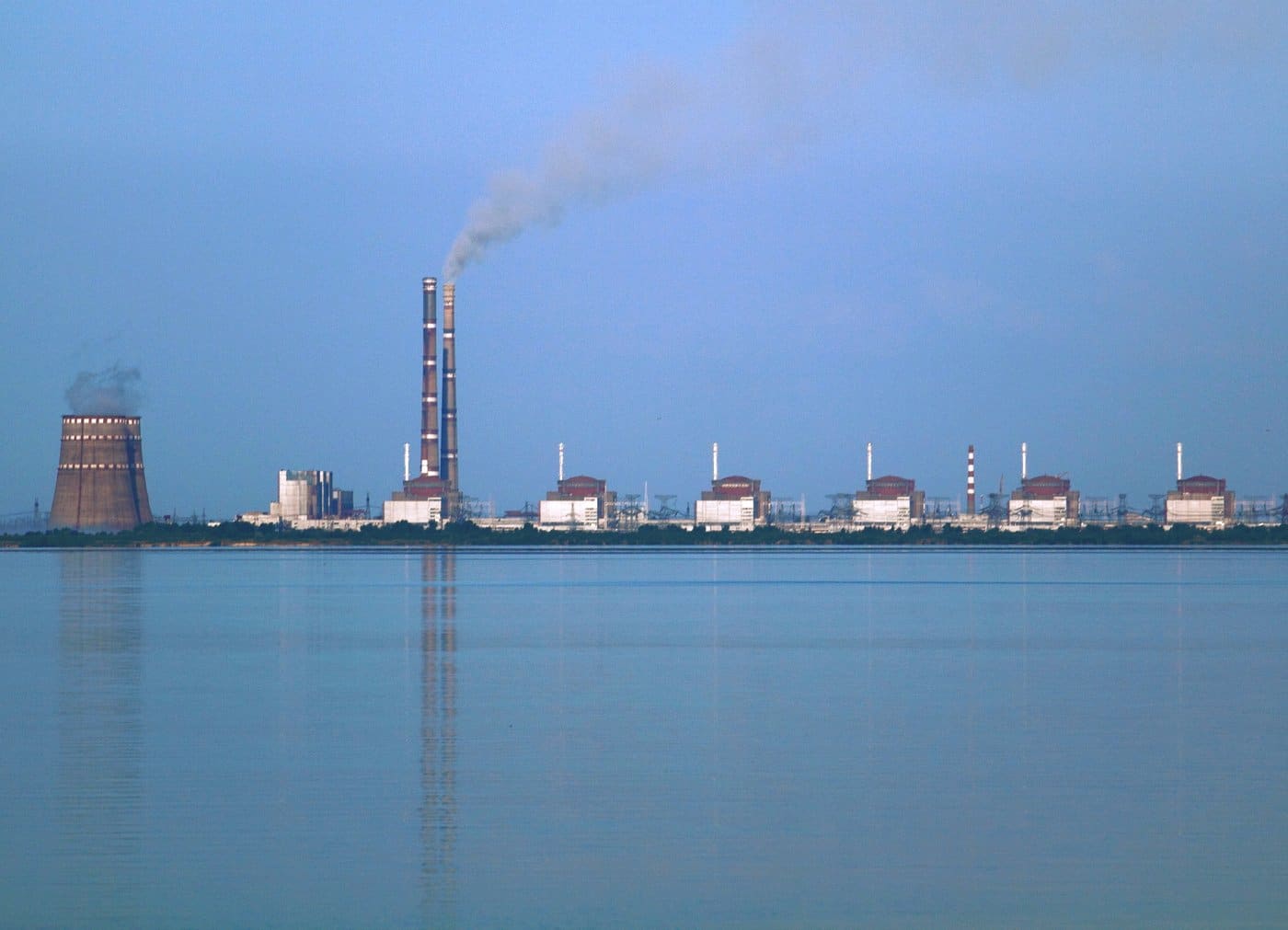 The Zaporizhzhia Nuclear Power Plant's reactor buildings and cooling tower viewed across the Kakhovka Reservoir