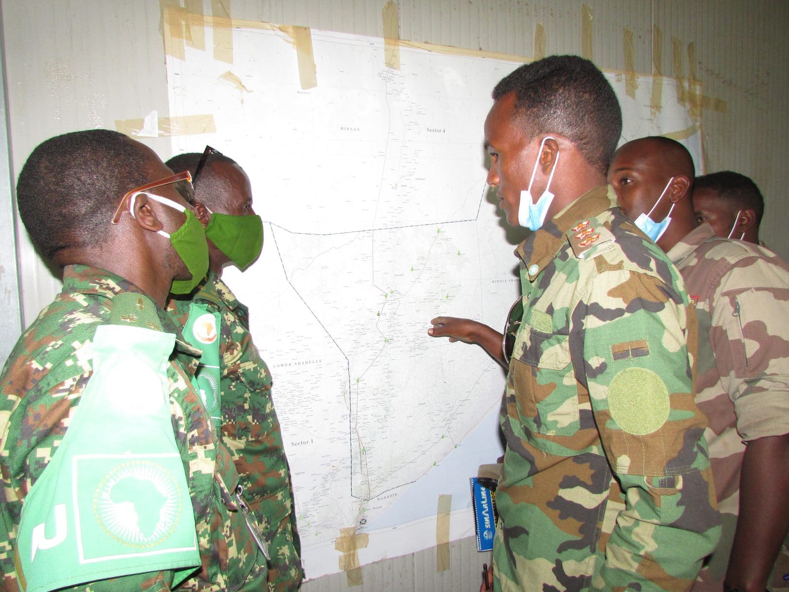 African Union and Somali security force personnel gather around a table for an offensive-planning meeting in Jowhar, Somalia