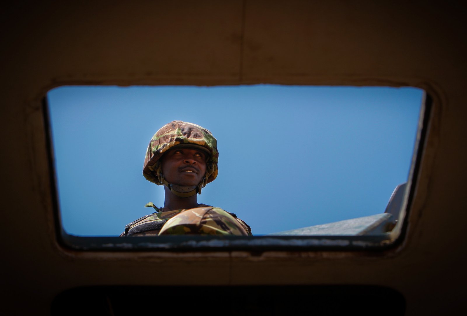 A gunner serving with AMISOM's Kenyan contingent is seen through the hatch of an armoured personnel carrier securing Kismayo