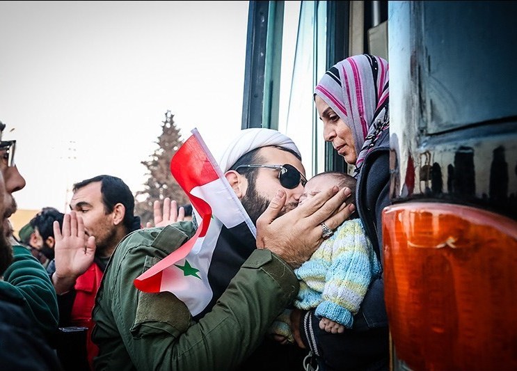 Residents evacuated from Al-Fu'ah and Kafriya arriving in Aleppo carrying Syrian flags, December 2016