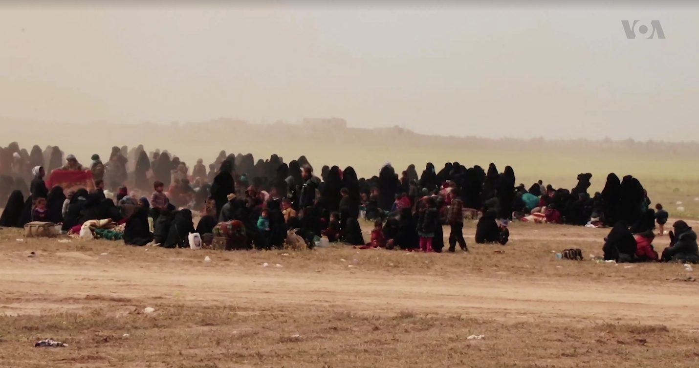 Civilians, mostly women and children, gathered at an SDF screening center evacuated from ISIS's last territorial holdout near Baghouz