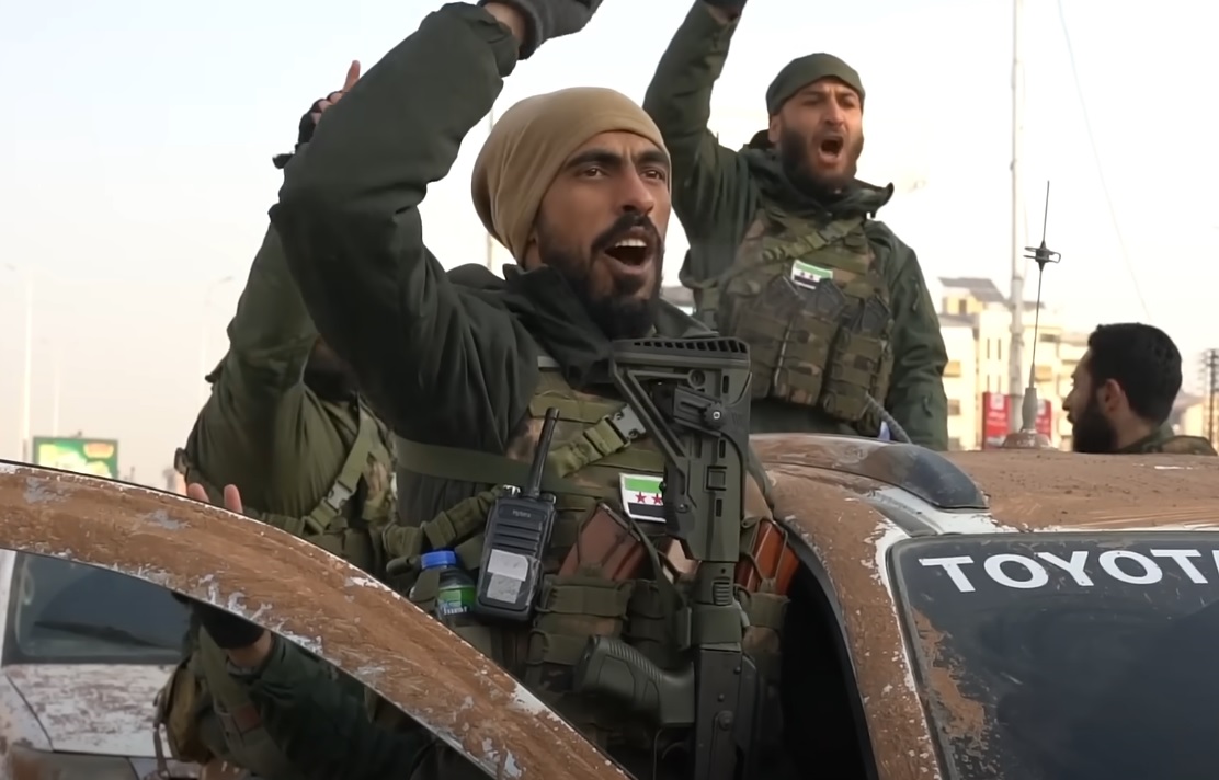 Armed opposition fighters in vehicles and on foot after taking control of Hama, Syria