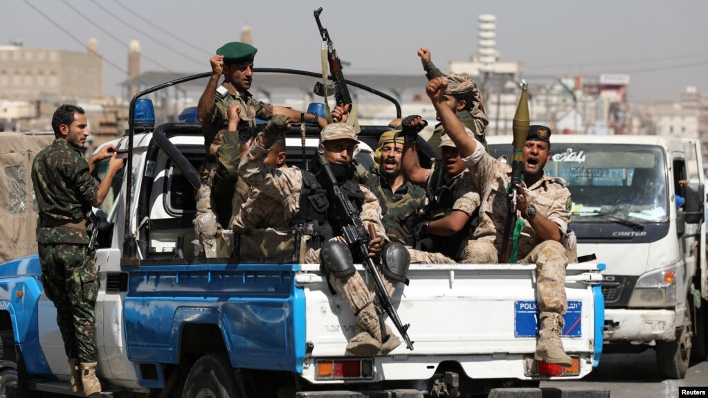 Houthi fighters ride in the back of a police pickup truck after a movement rally in Sanaa, the northern capital that has been under Houthi control since 2014
